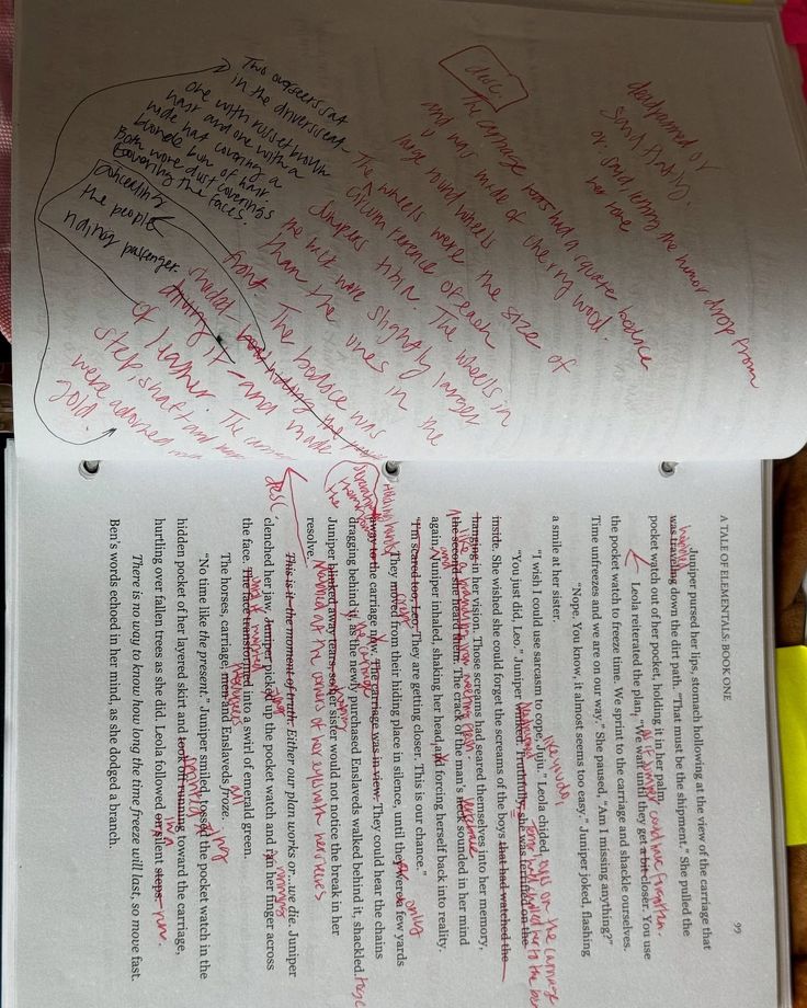 An open notebook of handwritten story notes above a printed proof page with red corrections